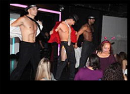 Male strippers dancing on stage taking it all off.